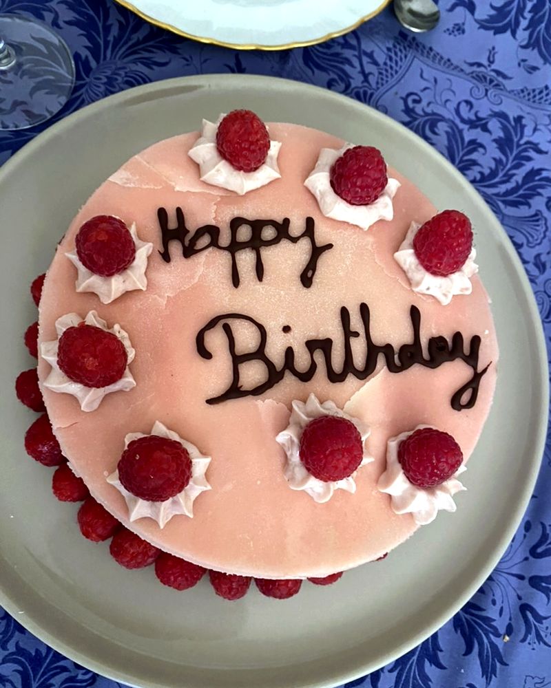 Framboisier rose décoré de framboises et écrit Happy Birthday au chocolat