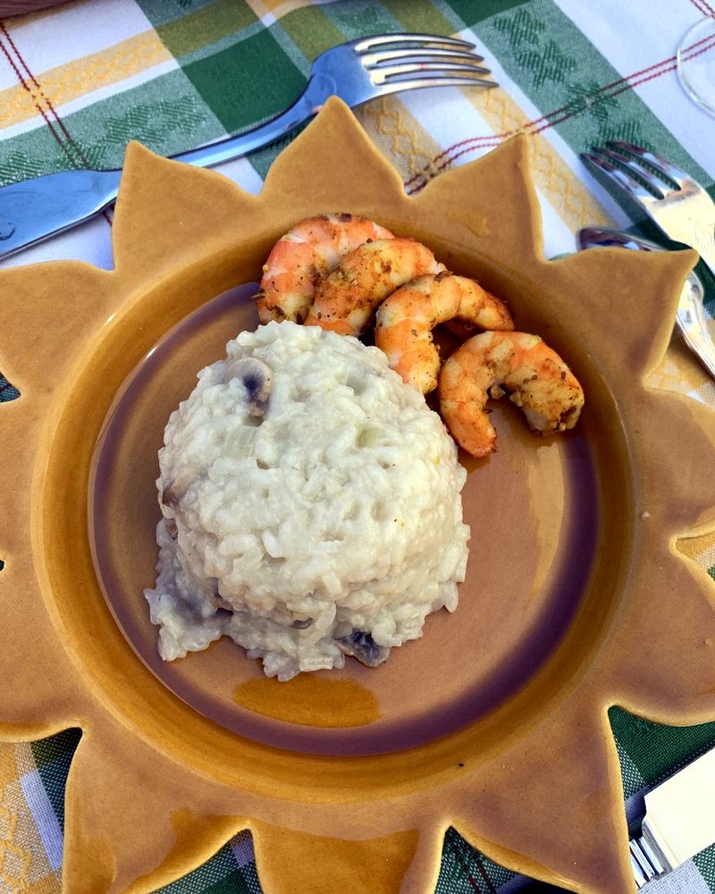 Dôme de risotto et crevettes poêlées dans une assiette en forme de soleil